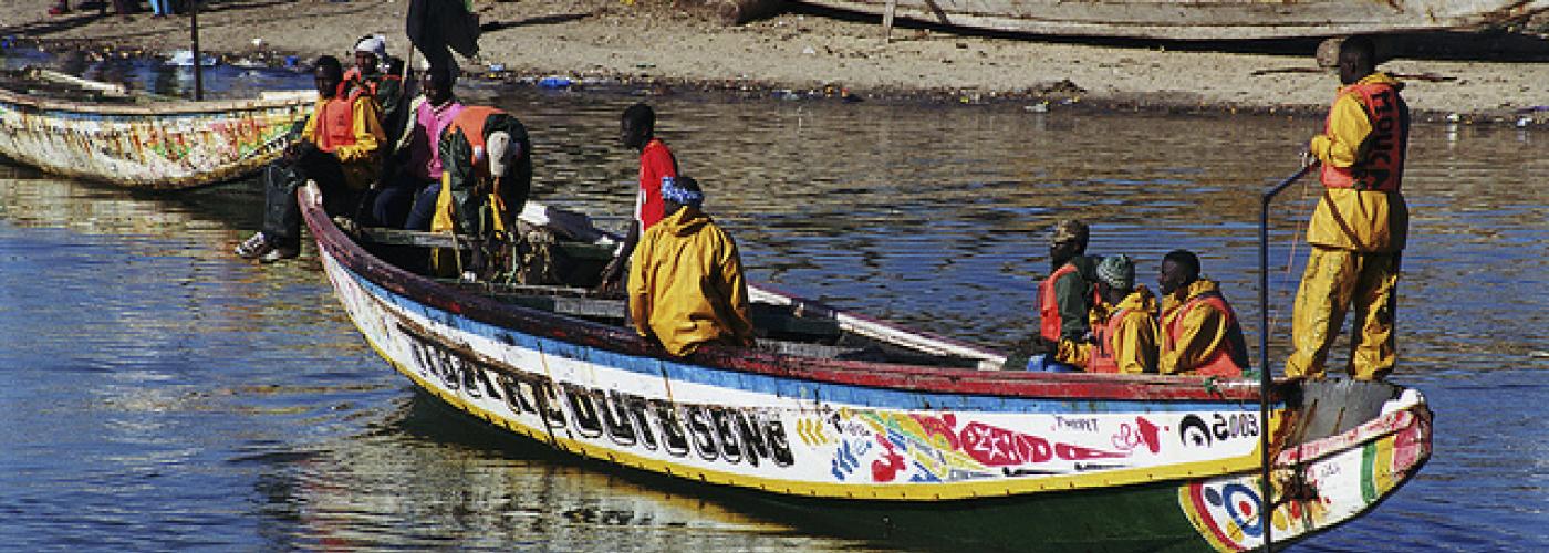 Municipal sanitation workers carry trash aboard boat. Photo: Scott Wallace / World Bank