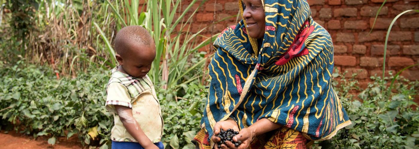 Mwanaidi shows her grandson the African nightshade seeds she harvested from her garden in Tanzania. Photo Credit: Rhiannon O'Sullivan, World Vegetable Center