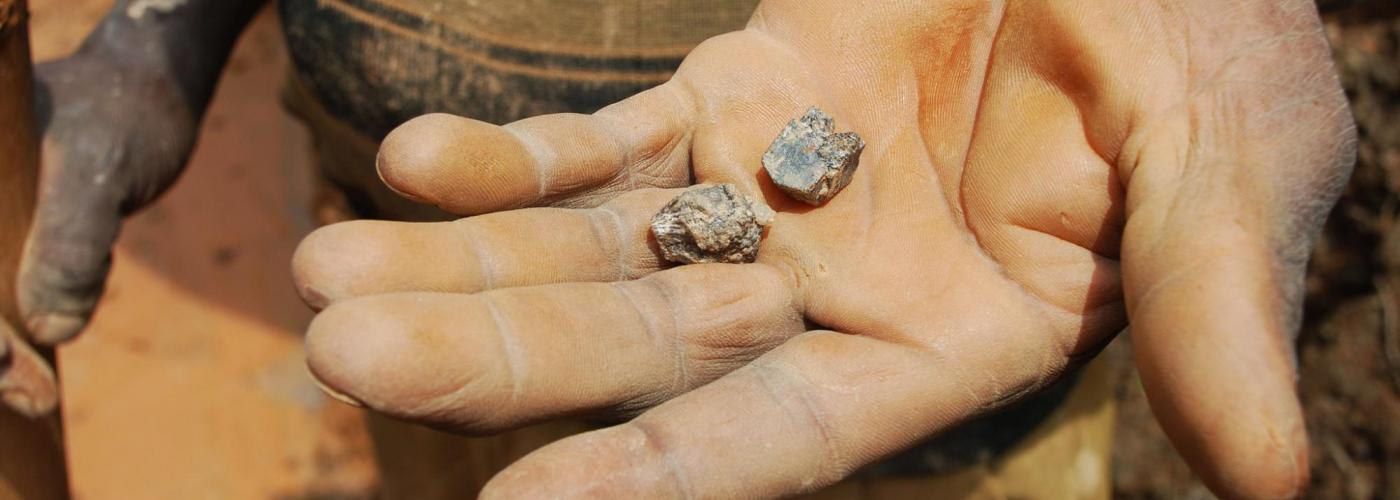 Photo description: A miner holds a piece of cassiterite in his palm in the DRC. Credit: Laura Heaton/Enough Project. 