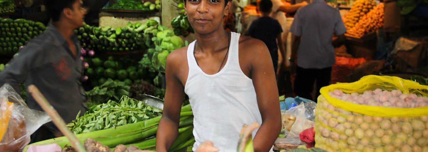 Photo: A young man sells his produce in a Dhaka market in Bangladesh.