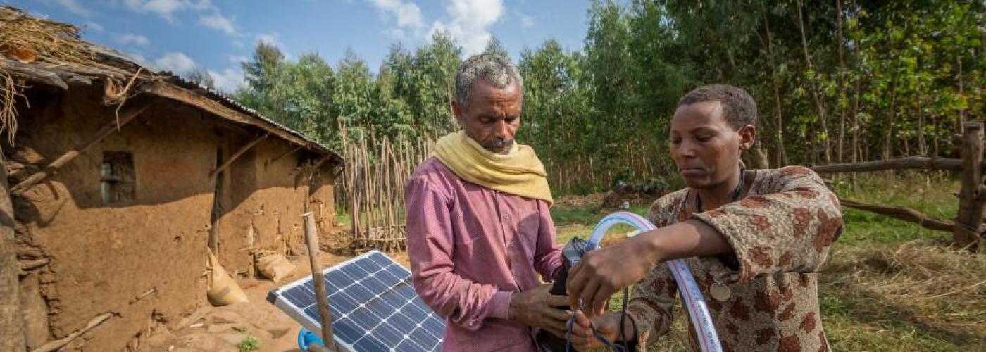 Sewagegn, a local smallholder farmer, and Gebeyaw, a data collector, set up Sewagegn's solar powered pump to irrigate her backyard garden in Danghesta, Amhara region of Ethiopia
