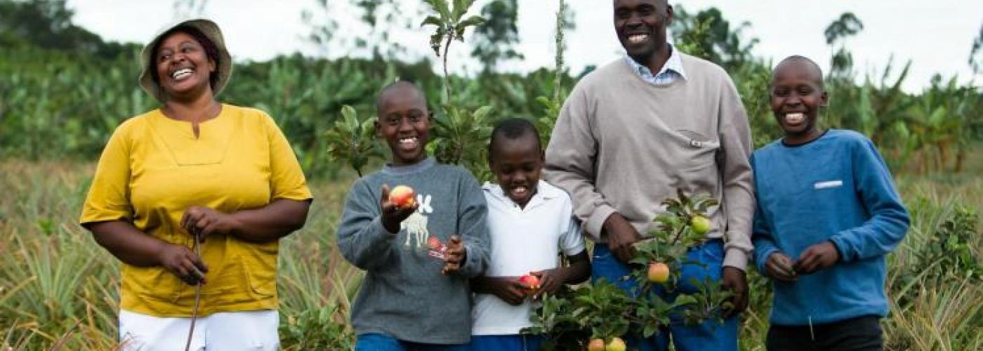 A family happily displays their fruit tree crop.
