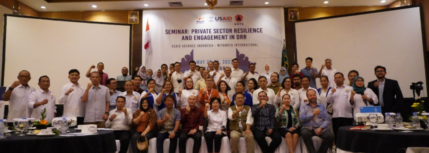 Photo: group of people with some standing and some sitting. All with fist in the air. KADIN National Disaster Risk Reduction Workshop held during the United Nations Global Platform for Disaster Risk Reduction (GPDRR) in Bali, Indonesia, May 2022.