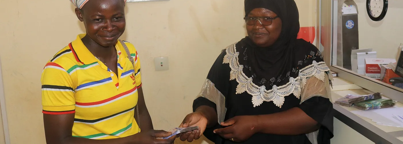 From left to right, Ouedraogo Asseta (member of the association Wend Kouni 2 Women) receiving a loan from Maiga Nematou, representative of Caisse Baitoul Maal (CBM). CBM is a microfinance institution and a grantee under the USAID CATALYZE Finance for Resilience (F4R) Activity.