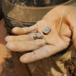 Photo description: A miner holds a piece of cassiterite in his palm in the DRC. Credit: Laura Heaton/Enough Project. 