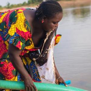 Women pump water from a river in Senegal