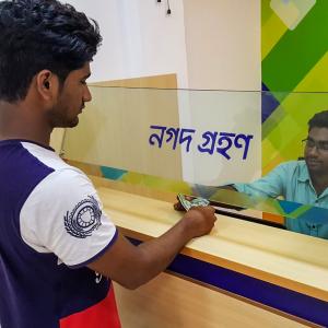 A man completes a transaction with a banking agent in rural Bangladesh.