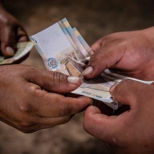 two pair of hands exchanging money 