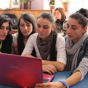 a group of women looking at a laptop screen