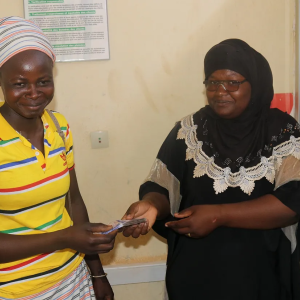 From left to right, Ouedraogo Asseta (member of the association Wend Kouni 2 Women) receiving a loan from Maiga Nematou, representative of Caisse Baitoul Maal (CBM). CBM is a microfinance institution and a grantee under the USAID CATALYZE Finance for Resilience (F4R) Activity.
